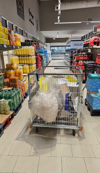 Pasillo de supermercado bloqueado por contenedor logístico en medio del recorrido, mostrando el impacto en la experiencia del cliente. Pasillo de supermercado bloqueado por contenedor logístico en medio del recorrido, mostrando el impacto en la experiencia del cliente.